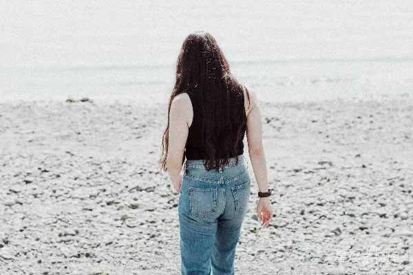 高清摄影 海边一位妇女正走在沙滩上。
