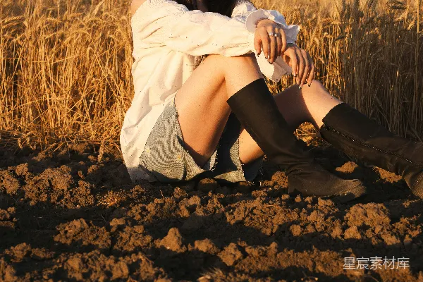 高清摄影 妇女坐在田野里，享受着阳光。