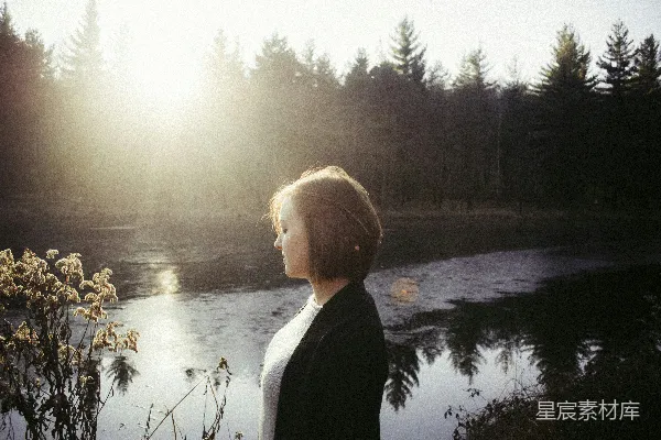 高清摄影 女人正在湖边看花。