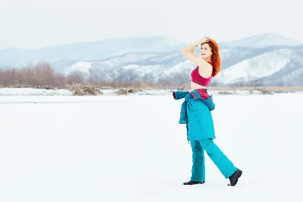 高清摄影 绿色长袖上衣和黑色长裤的女人站在覆盖着积雪的地面上，白天时间。