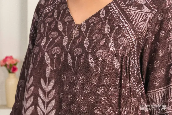 高清摄影 一个女人站在厨房里，穿着一件棕色上衣。