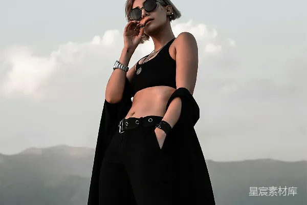 高清摄影 一个穿着黑色服装戴着太阳镜的女人正在打电话。
