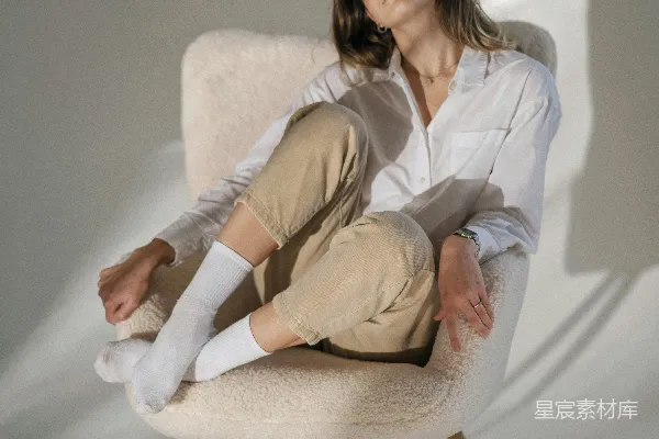 高清摄影 一个女人坐在椅子上，双腿交叉。