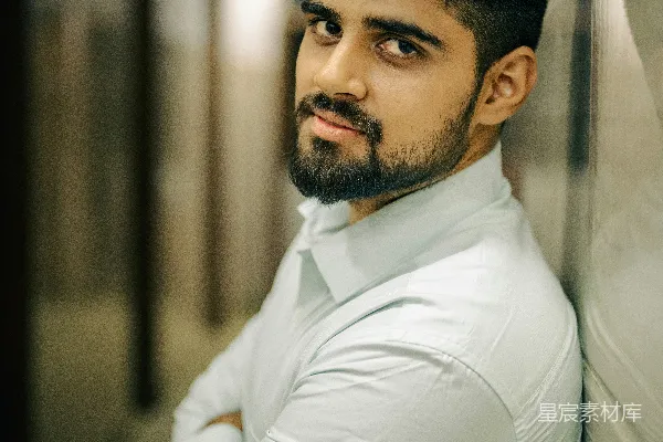 高清摄影 一个男人倚靠在墙边，双手交叉。