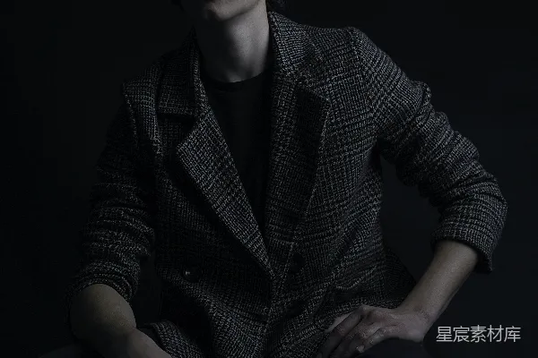 高清摄影 一个男人坐在一间黑暗房间里的椅子上。