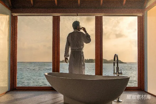高清摄影 男士站在浴室里，浴缸旁边有水体。