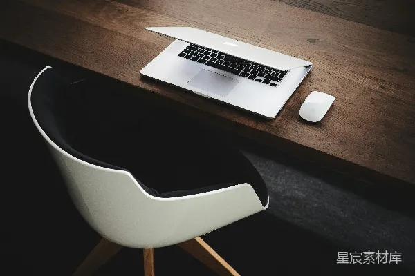 高清摄影 MacBook 旁桌上有一只计算机鼠标。