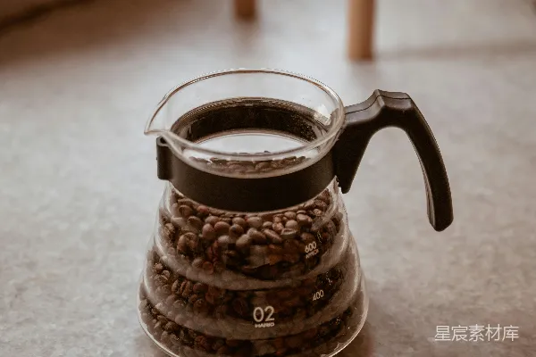 装满焙炒咖啡豆的玻璃咖啡壶。
