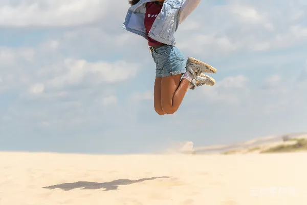 高清摄影 一个男人和一个女人在沙地上空跳跃。