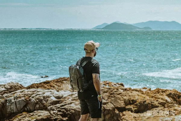 高清摄影 一个男人站在岩石上俯瞰着海洋。