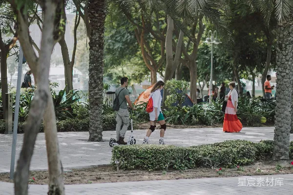 高清摄影 一群人走在路边的树旁 walking
