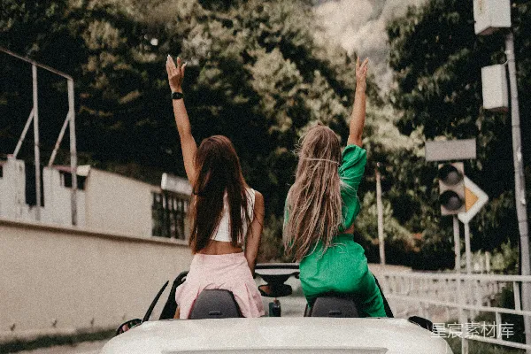 高清摄影 两名妇女坐在一辆白色 sports car 的后排。