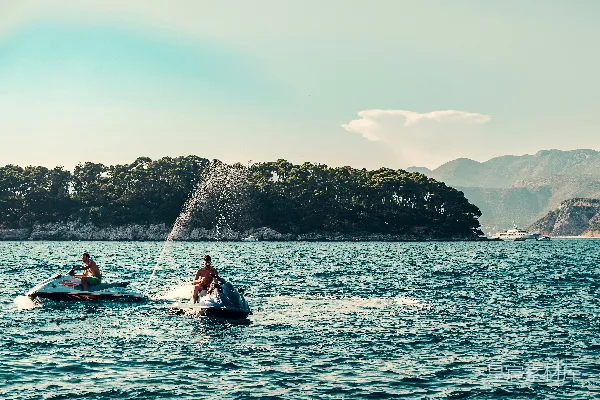高清摄影 身穿红衣的人在白天驾驶着白色和蓝色的 kayak 在海面上航行。
