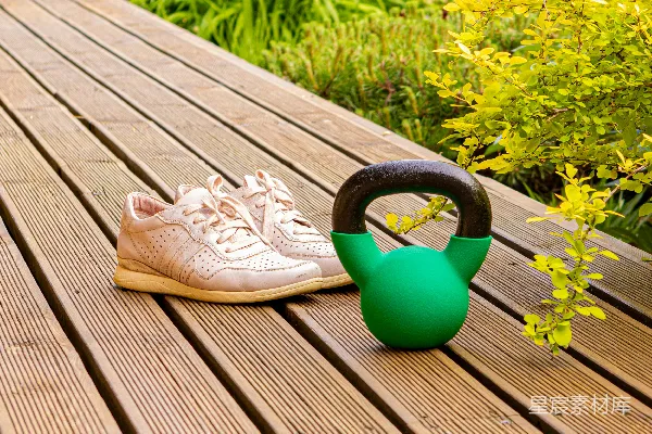 高清摄影 一双鞋放在木凳旁边，旁边放着一个浇水壶。