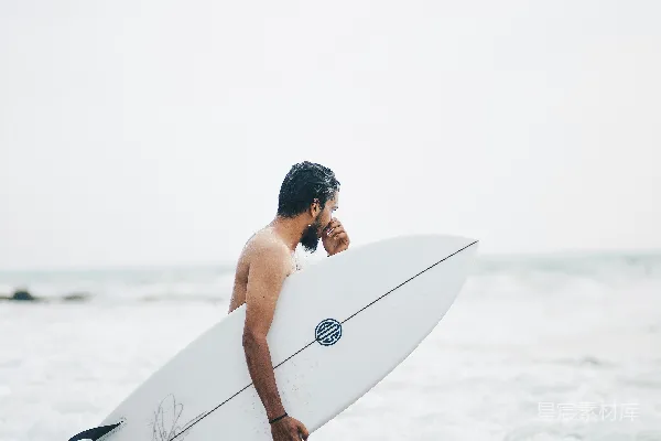 高清摄影 一个男人拿着冲浪板走向海洋