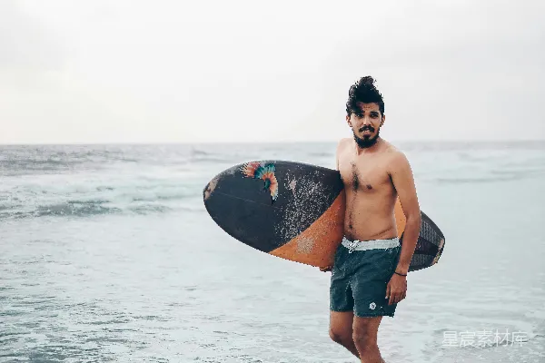 高清摄影 一个男人站在海边拿着冲浪板
