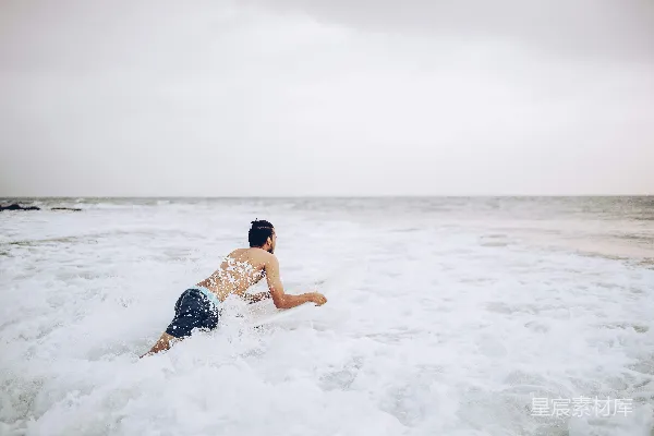 高清摄影 一个男子站在冲浪板上滑行在海浪上