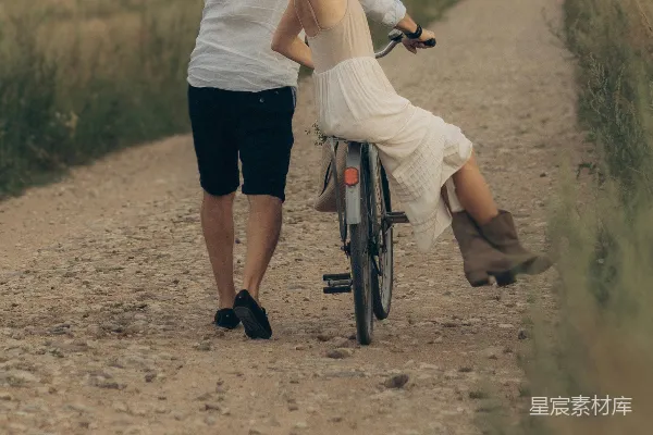 高清摄影 夫妻二人在一条泥路上骑自行车