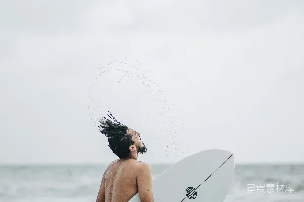 高清摄影 一个男人站在海边拿着冲浪板