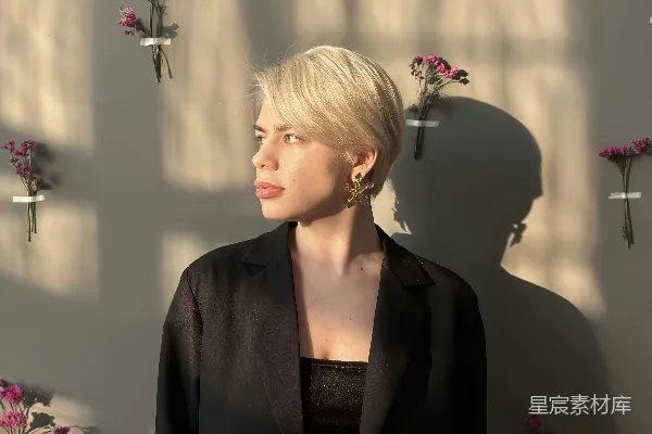 高清摄影 一个女人站在插有花的花瓶前面