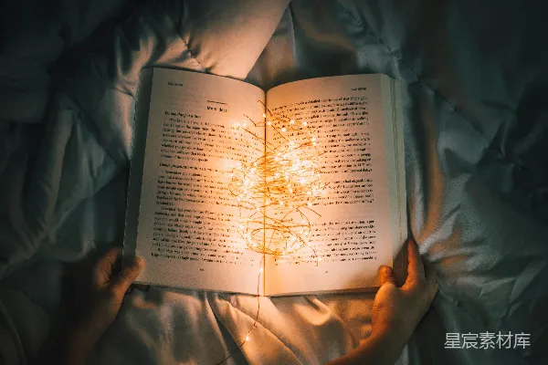 高清摄影 手持串灯的人站在打开的书本前
