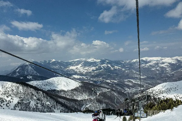 高清摄影 山顶上白天人们乘坐雪橇在覆雪的山间滑雪。