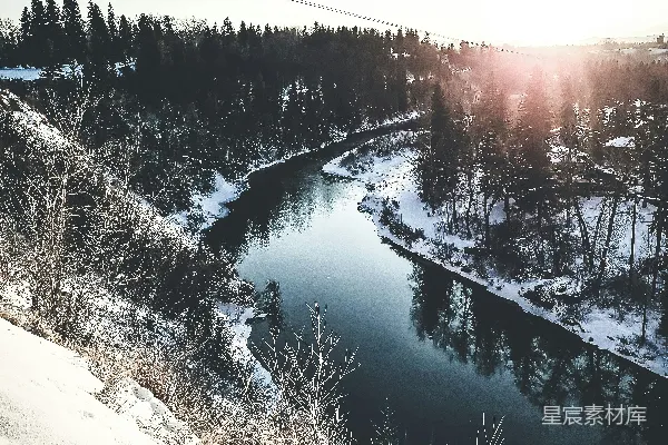 雪覆盖的田野和树木中间的一片湖泊