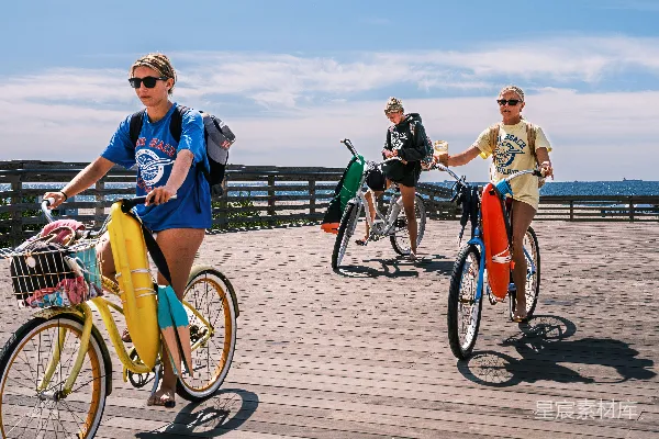 高清摄影 三个年轻人在木板walk上骑自行车。