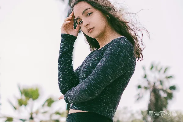 高清摄影 穿着长袖上衣和紧身 leggings 的女性站在户外。
