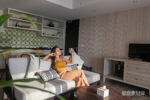 高清摄影 白衬衫黑条纹的女子坐在白黑相间的沙发上。