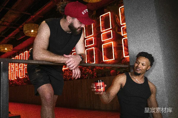 高清摄影 一个男人站在另一个男人旁边，手里拿着一个玻璃杯