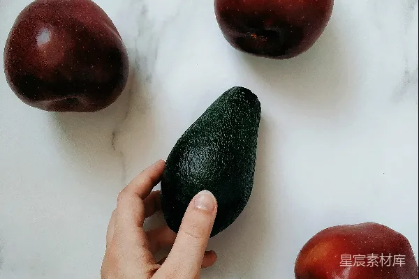 高清摄影 桌上的人正在剥一个鳄梨。