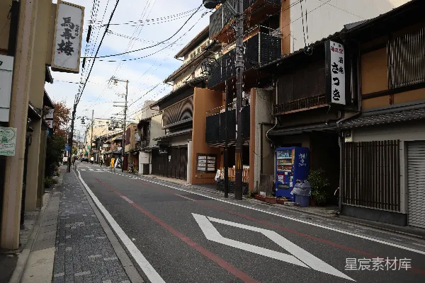 高清摄影 灰色的道路，远处没有车辆，近处建筑在白云蓝天之下。