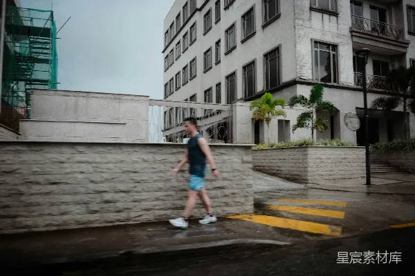 高清摄影 一个男人走在一栋高楼上边的街道上