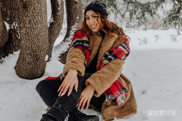 高清摄影 一个妇女坐在雪中穿着靴子。