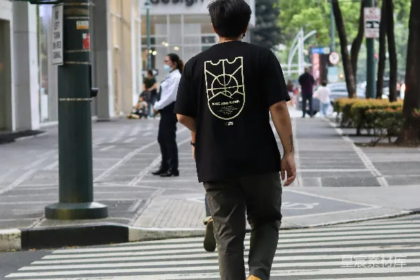 高清摄影 黑色T恤和棕色裤子的男人在白天步行在人行道上
