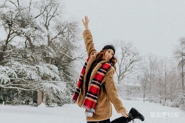高清摄影 一个女人站在雪地里，双臂高高举起。