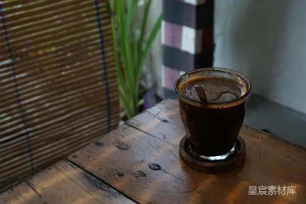 高清摄影 一个玻璃杯里装着液体放在一张木制桌子上