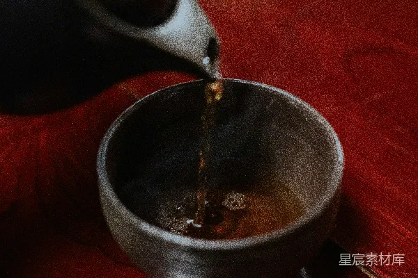 高清摄影 桌上一个人将茶倒入一个碗中。