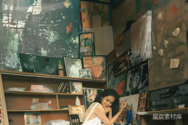 高清摄影 一位穿着白色连衣裙的女子坐在办公桌前。