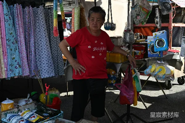 高清摄影 女人站在她的货摊前 selling goods。