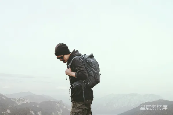 高清摄影 一个男人站在岩石上，俯瞰一片水域。