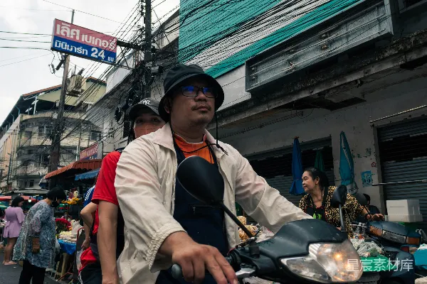 高清摄影 一个男人骑在摩托车后座上沿着街道前行。