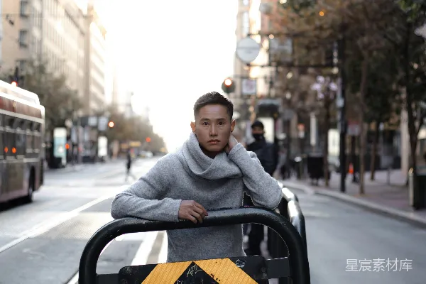 高清摄影 灰色卫衣的男人坐在黑色和黄色的路标上，白天。