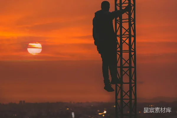高清摄影 夕阳下男子攀爬塔楼的轮廓