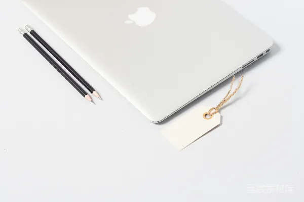 高清摄影 MacBook Air 近处的特写照片，旁边有几支铅笔。