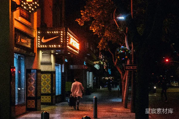 高清摄影 夜晚行人走在店铺旁的照片