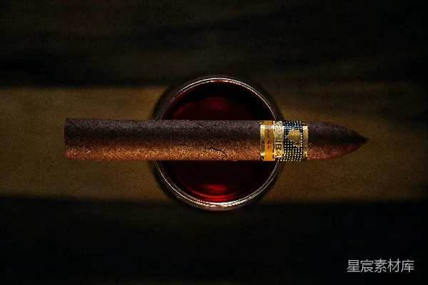 高清摄影 一支雪茄放在一杯深色液体上。