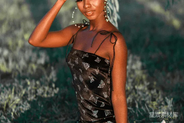高清摄影 黑色白色花卉花纹 spaghetti 型领连衣裙的女人坐在白色织物上。