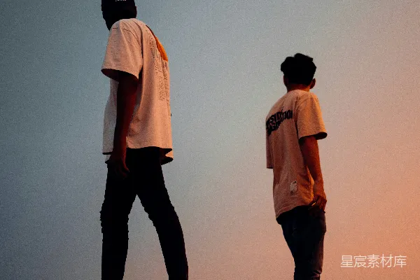高清摄影 白衬衫着装的男人站在穿白衬衫的男人旁边，裤子是黑色的。